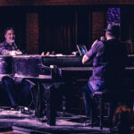 Two piano players dueling on stage playing for a crowd