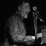 Man singing playing piano