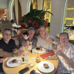 4 men enjoying a meal at a restaurant table