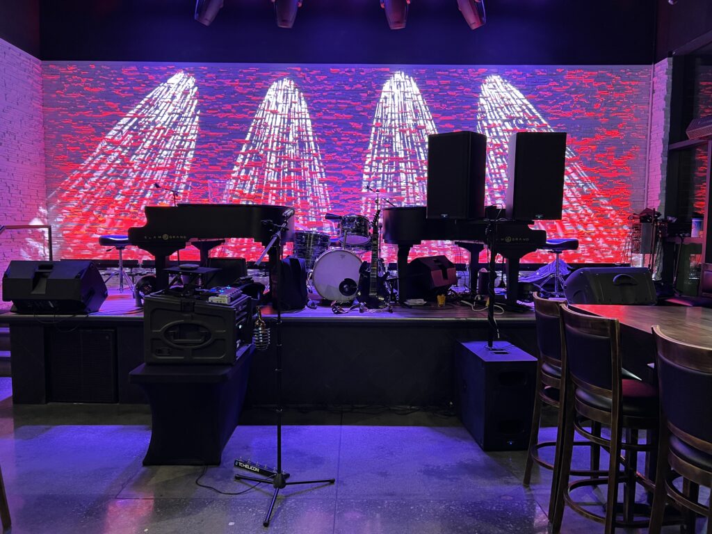 Piano and other instruments on stage with set lighting