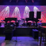 Piano and other instruments on stage with set lighting