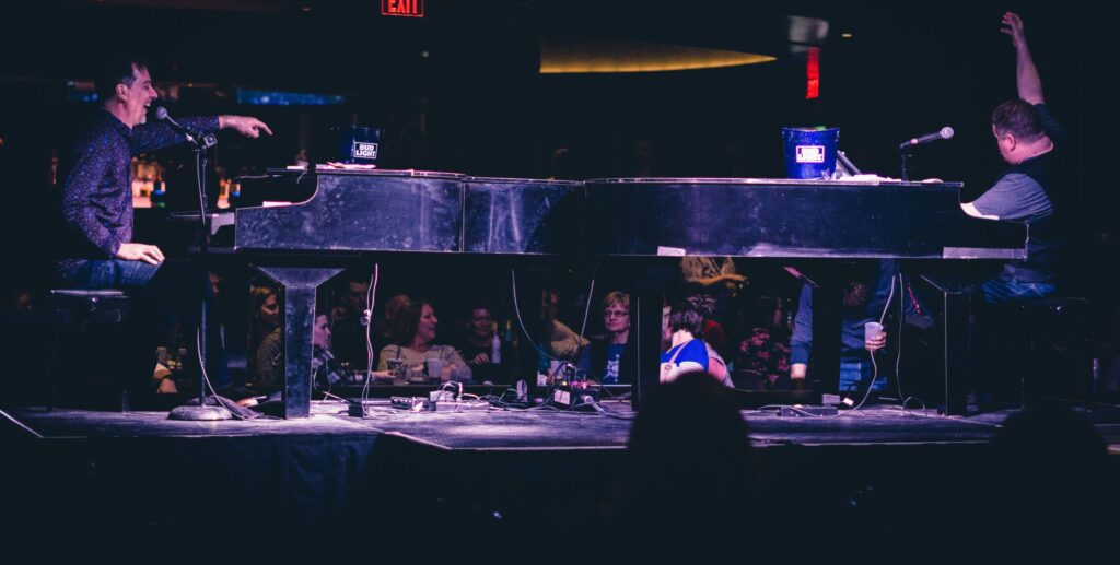 Two men on stage playing piano