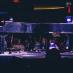 Two men on stage playing piano